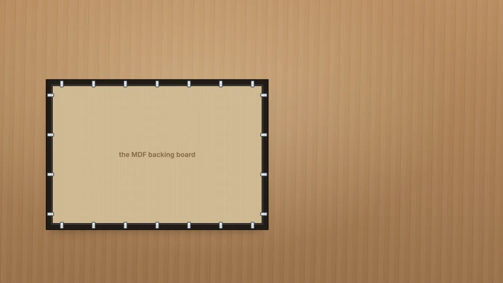 The back of the vinyl frame, face down, with the flexible tabs lifted out of the way.