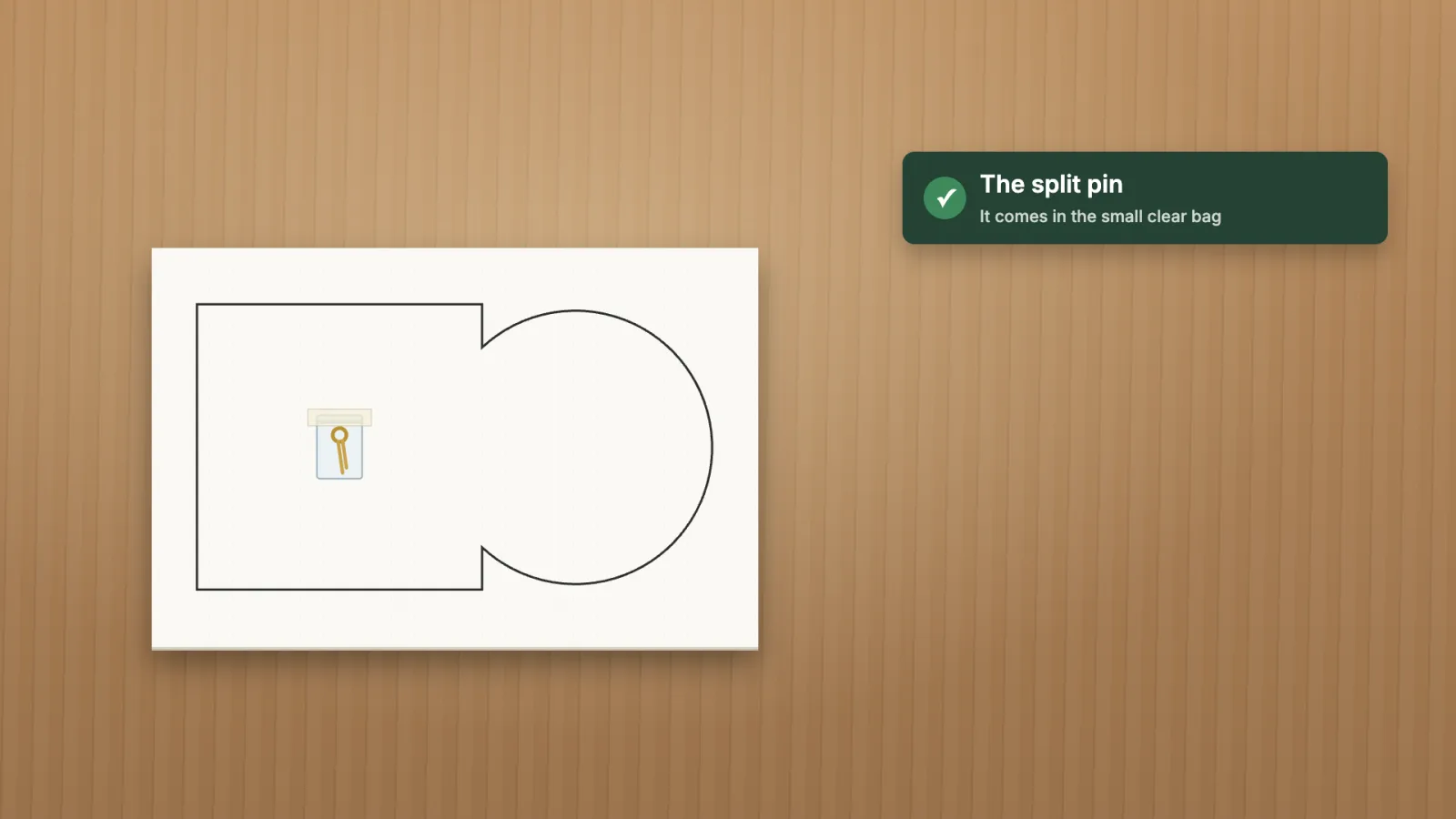 The template board printed with the outline of a sleeve and a record, with the split pin in its bag.