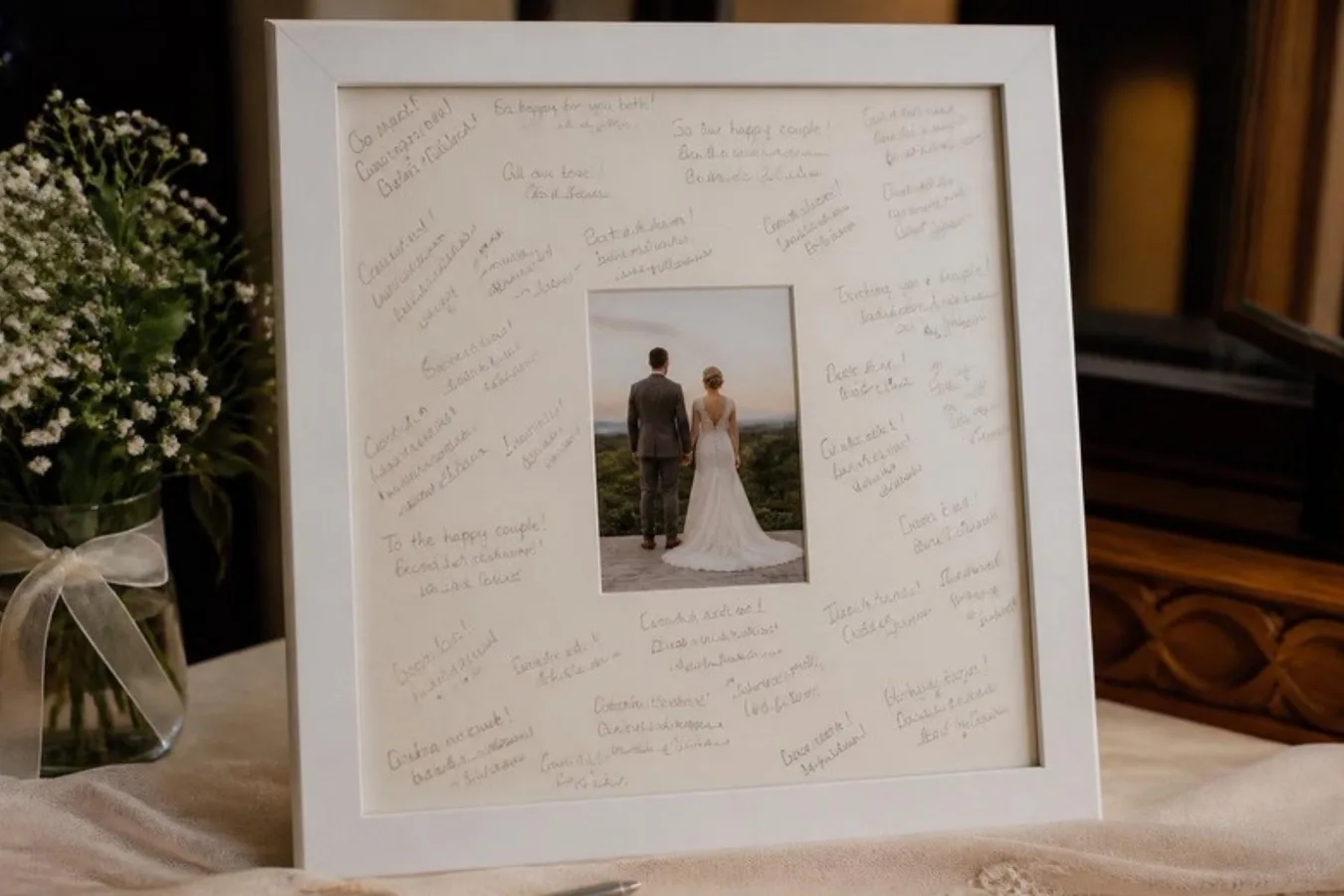 A signature frame holding a wedding photo, its wide mount covered in guests' handwritten messages